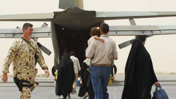 Escape to freedom ... soldiers usher interpreters and their relatives onto a mercy flight.