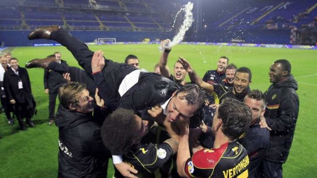 Time to celebrate: Belgium's coach Marc Wilmots celebrates with his players after securing qualification to the 2014 World Cup.