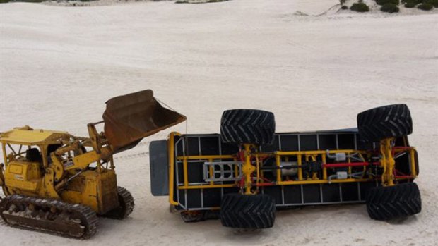 The crashed four-wheel-drive lies on its side in the Lancelin dunes.