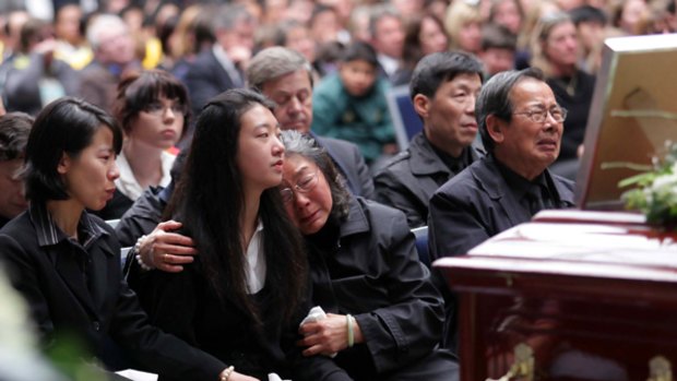 Brenda Lin, 15 (centre), the sole surviving member of her immediate family, is comforted at the service by her paternal aunt Shu ‘‘Kathy’’ Lin, left, and grandmother Zhu Fengqin.