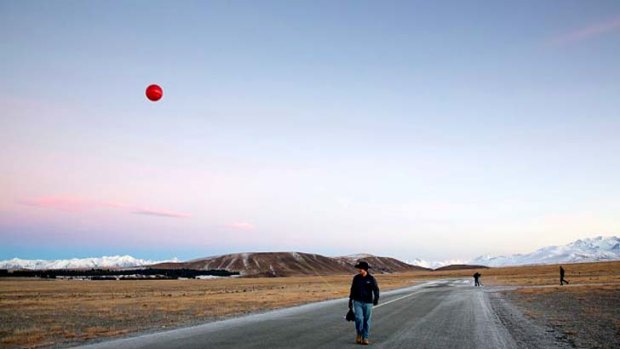 Project Loon team members Paul Acosta and Peter Capraro placed red balloons near the launch site at sunrise. 