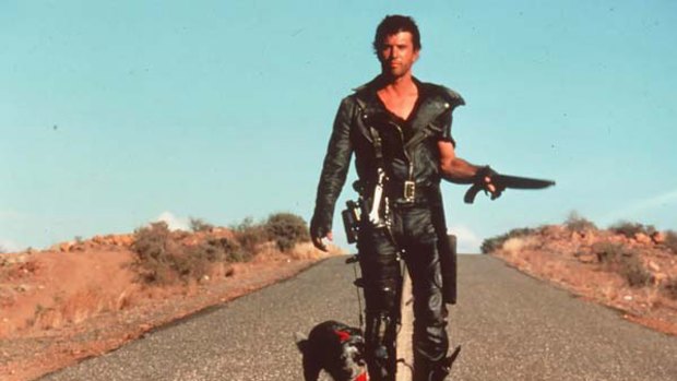 Mel Gibson saunters down a road in the original Mad Max movie.