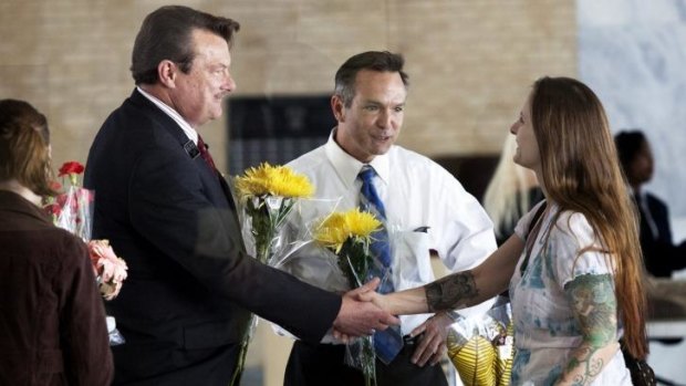 Larissa Boose Williams, right, and her daughter Sedona, 10, hand out flowers to Tony London, left, and Tim Bostic after they become the first couple to obtain a gay marriage in the state of Virginia.