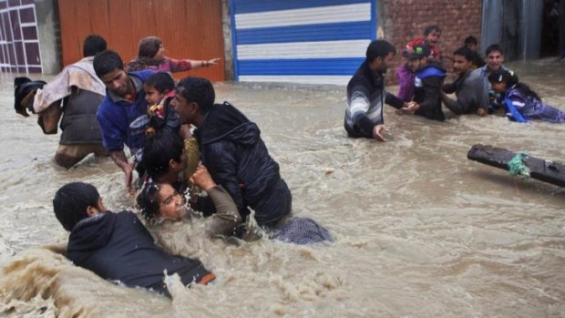 Kashmiri residents struggle to withstand sudden and strong water currents while wading through floodwaters in their efforts to move to safer places in Srinagar, India.