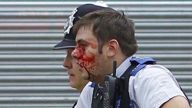 Violent clashes ... a police officer is helped to safety by a colleague.