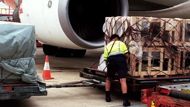A worker loads airfreight in Sydney.