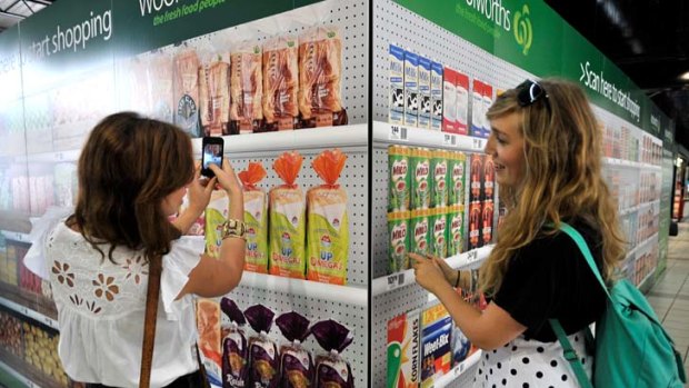 Groceries in a snap &#8230; shoppers use smart phones to scan goods for home delivery at a Woolworths virtual store.