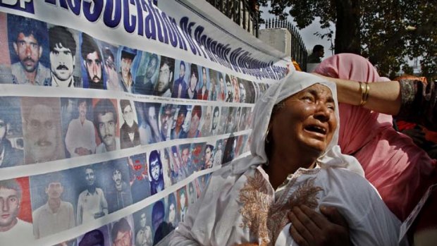 Looking for answers ... a grieving mother weeps during a rally in Srinagar as she looks at a wall of photographs of missing men and boys about 8000 of whom have disappeared in the last 20 years.