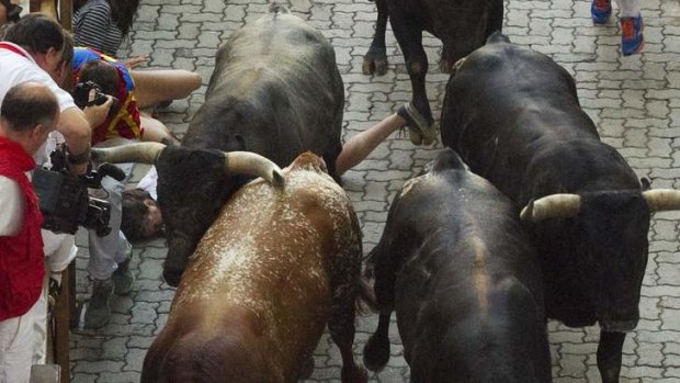 An unidentified 23-year-old Australian woman lies on the ground after being gored by a Miura fighting bull during the last running of the bulls of the San Fermin festival in Pamplona.