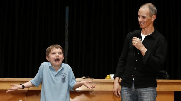 Ainslie School year 2 student Taj Whitney-Nash helps author Andy Griffiths demonstrate what happens when you shrug your shoulders while making an evil laugh.
