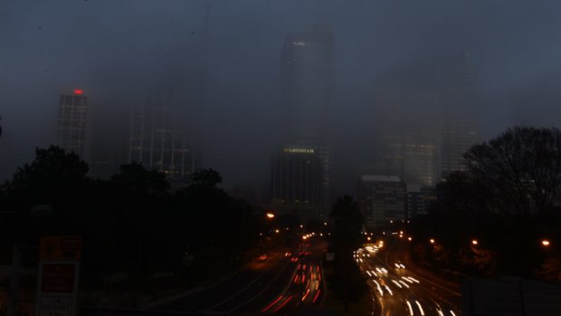 Fog covers traffic along the Cahill Expressway for a second morning in Sydney.