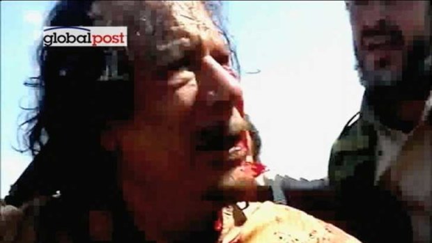 Last moments of a tyrant: Former Libyan leader Muammar Gaddafi after his capture by NTC fighters.