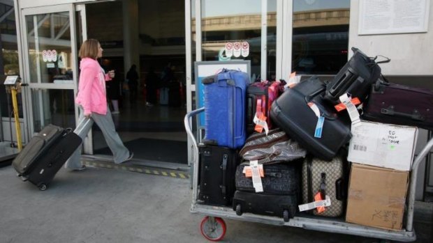 A passenger enters the terminal Los Angeles International Airport, where police allege six baggage handlers were involved in property theft on a massive scale.