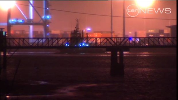 Crews work to clear an oil spill at the Port of Brisbane on Monday. Staff at the Port of Brisbane noticed the slick just after midnight, but authorities were unable to determine the extent of its spread in the dark.