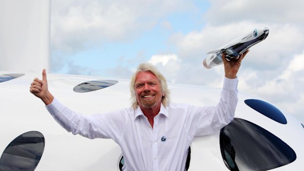 Sir Richard Branson poses with his Virgin Galactic Space craft at Britain's Farnborough International Airshow in 2012.