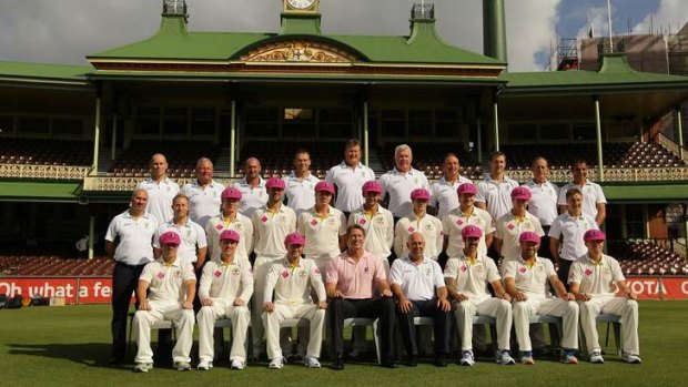 United cause: The Australian team poses with Glenn McGrath and the baggy pink cap they will wear for the Pink Test at the SCG.