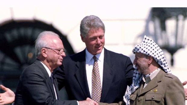 Yasser Arafat and Yitzhak Rabin shaking hands at the White House signing ceremony of the Oslo Accords in 1993, watched by President Bill Clinton.