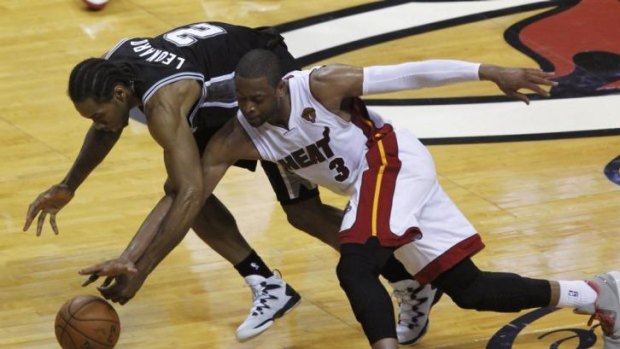 San Antonio Spurs' Kawhi Leonard (L) steals the ball from Miami Heat's Dwyane Wade.