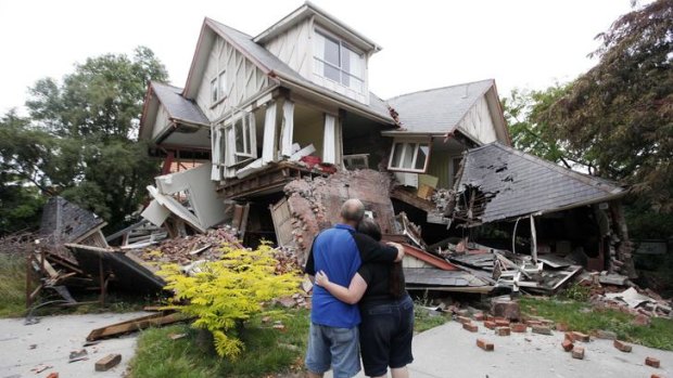 In this February 23, 2011 photo Murray and Kelly James look at their destroyed house in central Christchurch, a day after the deadly earthquake.