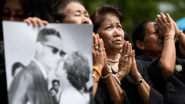 Huge loss: Mourners pray outside the Grand Palace in Bangkok.