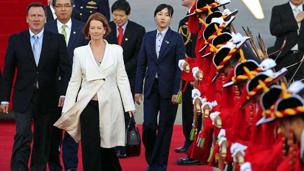 Julia Gillard and partner Tim Mathieson inspect a guard of honour at Seoul military airport.