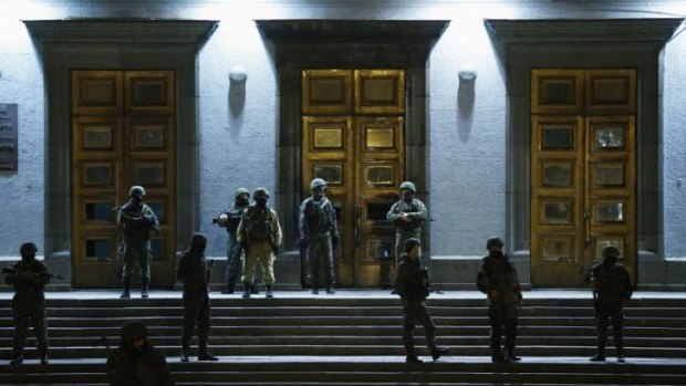 Armed men stand guard at the local government headquarters in Simferopol, Crimea.