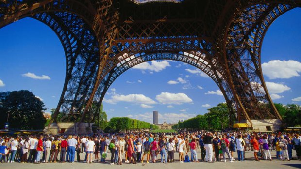 Tourists queuing at base of Eiffel Tower, Paris, France.