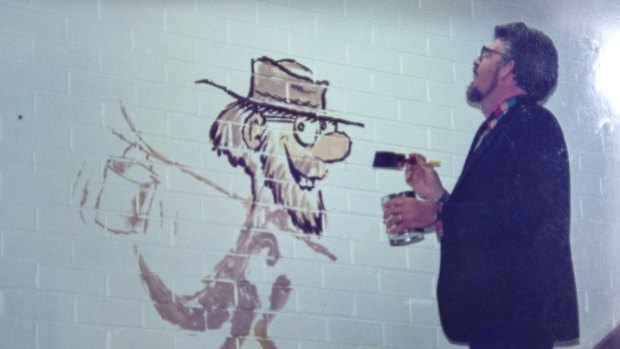 Rolf Harris paints the mural at Penhalluriack's Building Supplies in Caulfield in 1990.