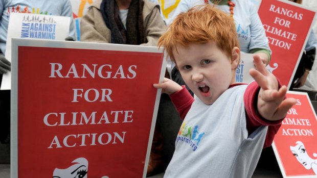 Five year-old Findlay Gledhill holds a banner as a group of red heads rallying for climate action.