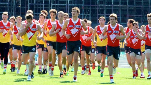 All in his stride: Kurt Tippett (centre) leads the Swans out on Wednesday.
