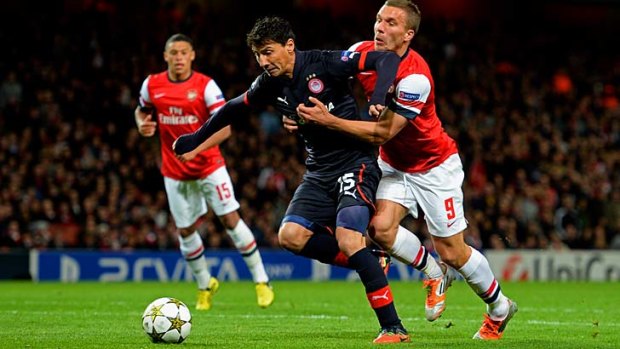 Marquee signing: New Melbourne Victory signing Pablo Contreras, formerly of Olympiacos, shields the ball from Arsenal's Lukas Podolski during last season's Champions League.