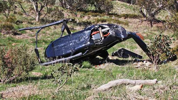 A helicopter lies on the side of a hill after crashing at Mount Buller. Four people walked away from the crash.