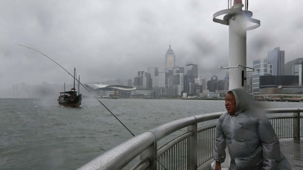Calm before the storm: A fisherman battles against the wind at Hong Kong's Victoria Harbour.