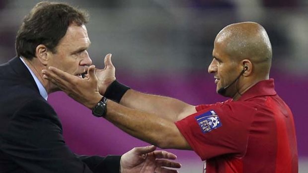 Referee Ali Al Badwawi asks Australia's coach Holger Osieck of Germany to return to the dugout.