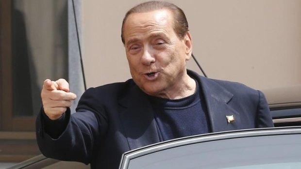 Silvio Berlusconi smiles as he leaves the "Sacra Famiglia" foundation near Milan. 