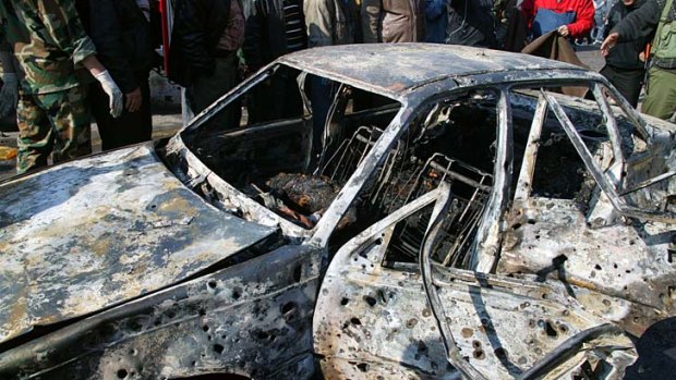 A car which was destroyed by one of the bombs at a security service base in Damascus.