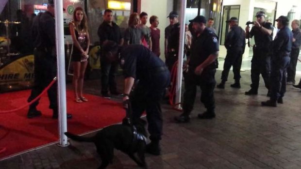 Bystanders watch on as police conduct raids as part of Operation Kilo Fraction