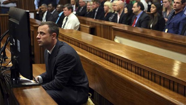 World watches: Oscar Pistorius sits in court in Pretoria before his trial for the murder of girlfriend Reeva Steenkamp.