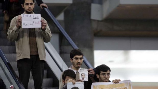 Tensions ... An Iranian protester holds a placard against Israel and International Atomic Energy Organization, IAEA.