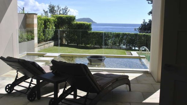 The pool is surrounded by lawn and hedges.