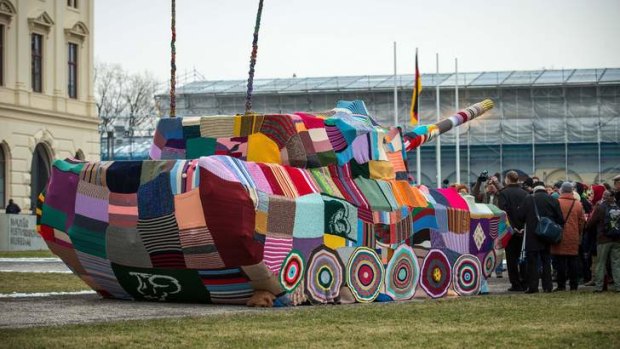 Knitted quilt ... Local peace activists have wrapped a tank in front of the Bundeswehr Military History Museum.