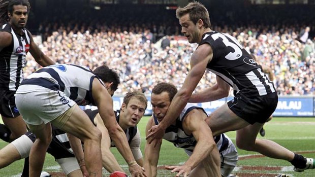 In the thick of it: Magpie Ben Reid (centre) scrambles for the ball.