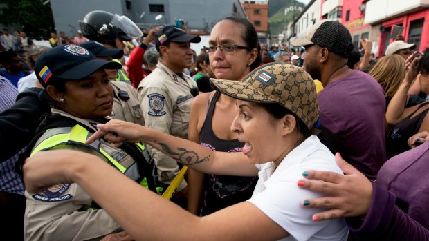 A woman argues with the police during a protest for food in Caracas, Venezuela.