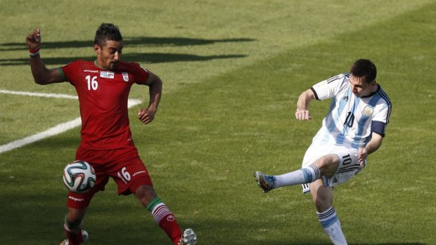 Argentina's forward and captain Lionel Messi (right) shoots past Iran's forward Reza Ghoochannejhad to score during their Group F match.