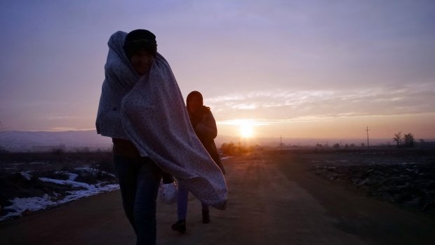 Migrants try to keep warm as they cross the Macedonian-Serbian border in sub-zero temperatures.