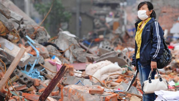 A woman stands among the remains of her home in Hanwang after the earthquake.