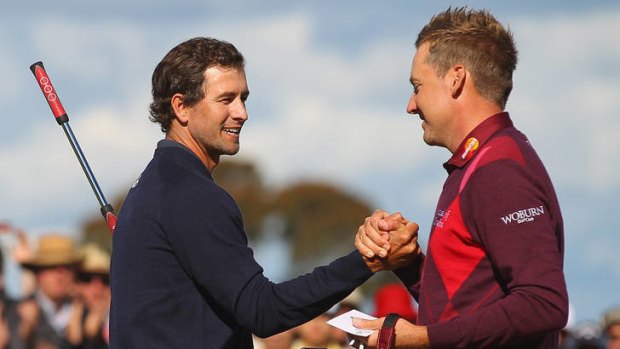 Adam Scott is congratulated by Ian Poulter on the 18th.