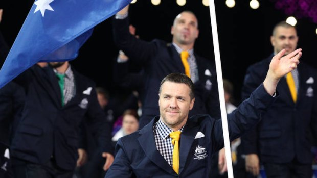 Wheelchair rugby player Greg Smith carries the flag for Australia.