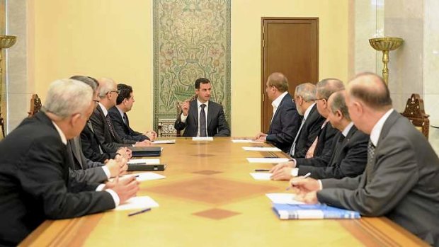Syria's President Assad (centre) meets members of a ministerial committee responsible for establishing a framework aimed at ending the two-year conflict with anti-government forces, in this handout photograph distributed by Syria's national news agency.