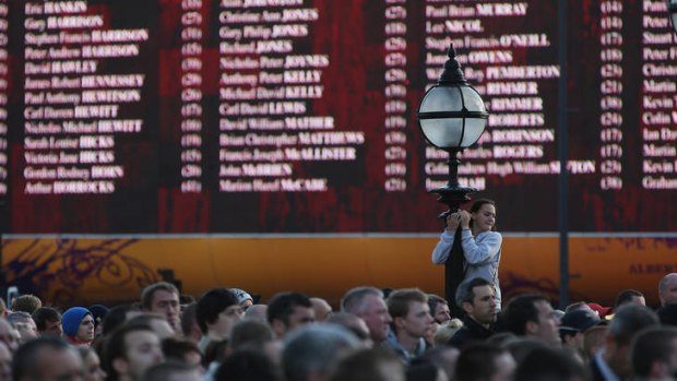 A giant screen displays the nakes of the victims of the Hillsborough disaster.